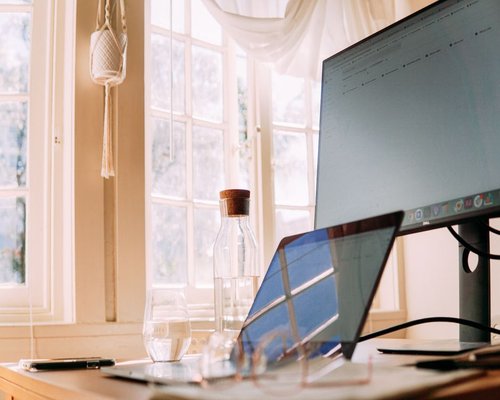 Organized work desk with water and natural light